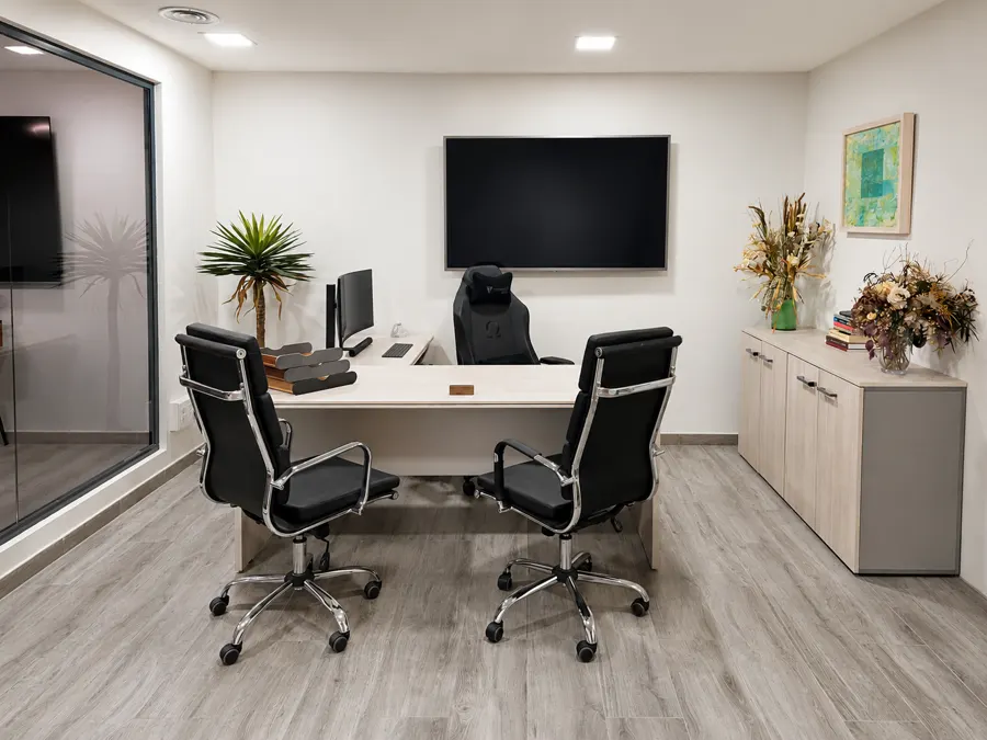 Despacho principal: mesa en L, dos sillas para la visita y pantalla de trabajo