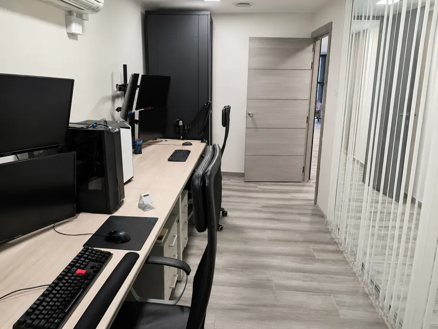Puestos de trabajo del equipo, con los monitores y el armario de comunicaciones