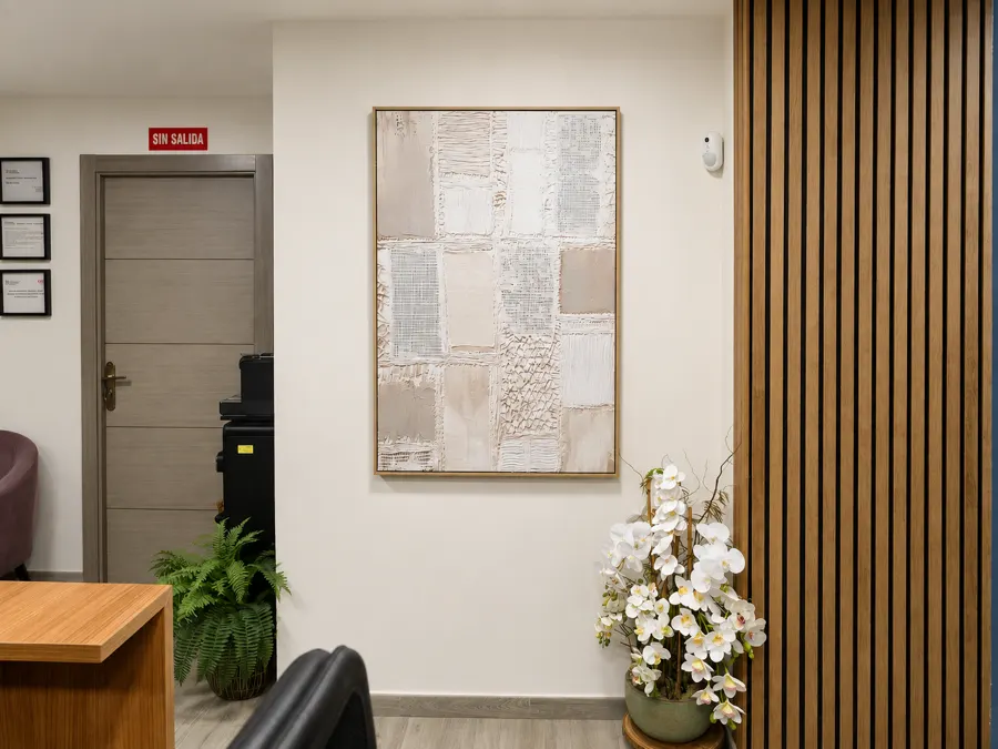 Detalle del mostrador de recepción con el ordenador y el logotipo al fondo