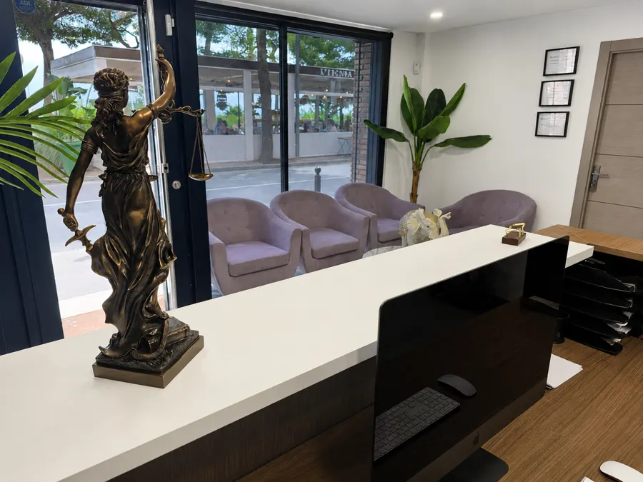 Mostrador con la figura de la justicia y, al fondo, las butacas de la sala de espera junto al ventanal